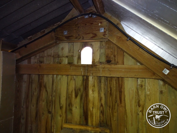 A small ventilation window in the wall of a wooden barn